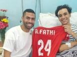 أحمد فتحي يزور مشجع الأهلي المصاب.. ويهديه قميصه