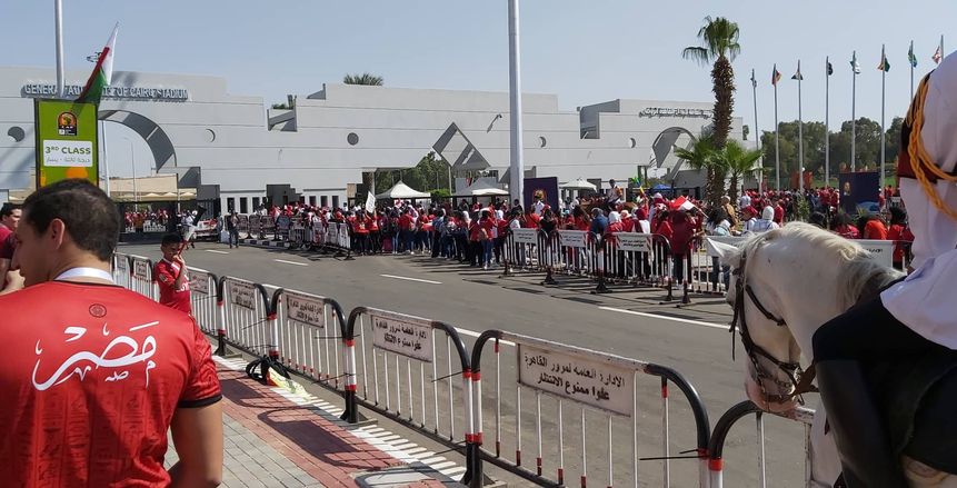 بالصور| بالأحمر وأعلام مصر.. أجواء كرنفالية للجمهور بمحيط استاد القاهرة
