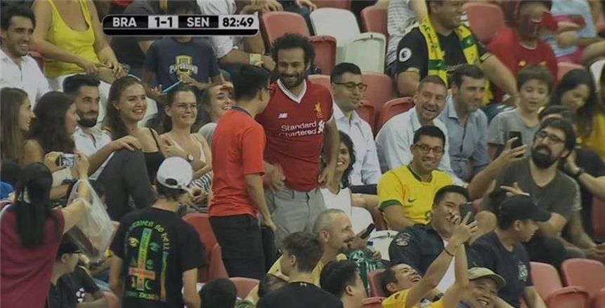 بالصور.. شبيه صلاح يمنح قميص ليفربول لأحد المشجعين بمباراة البرازيل والسنغال